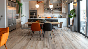 Contemporary kitchen with light wood flooring, a wooden dining table surrounded by colorful chairs, modern lighting, and large windows.