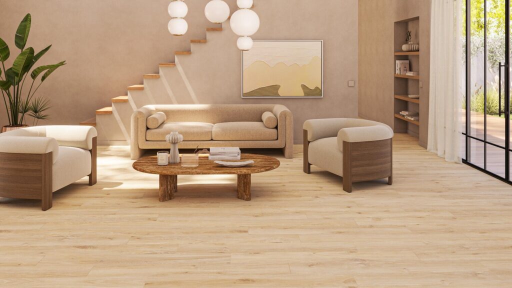 Cozy modern living room with light wood flooring, beige furniture, round wooden coffee table, and natural light from glass doors.