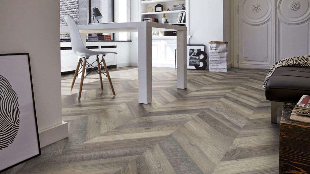 Modern interior with herringbone patterned wood flooring in a stylish living and office space.