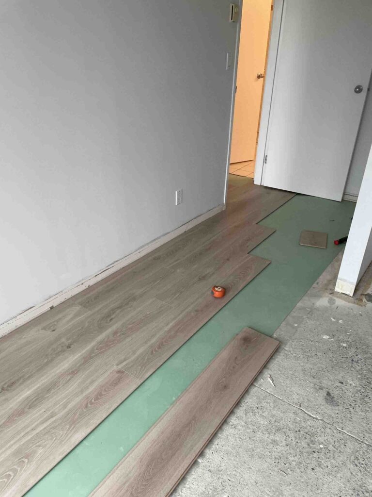 SPC vinyl flooring installation with underlayment in progress