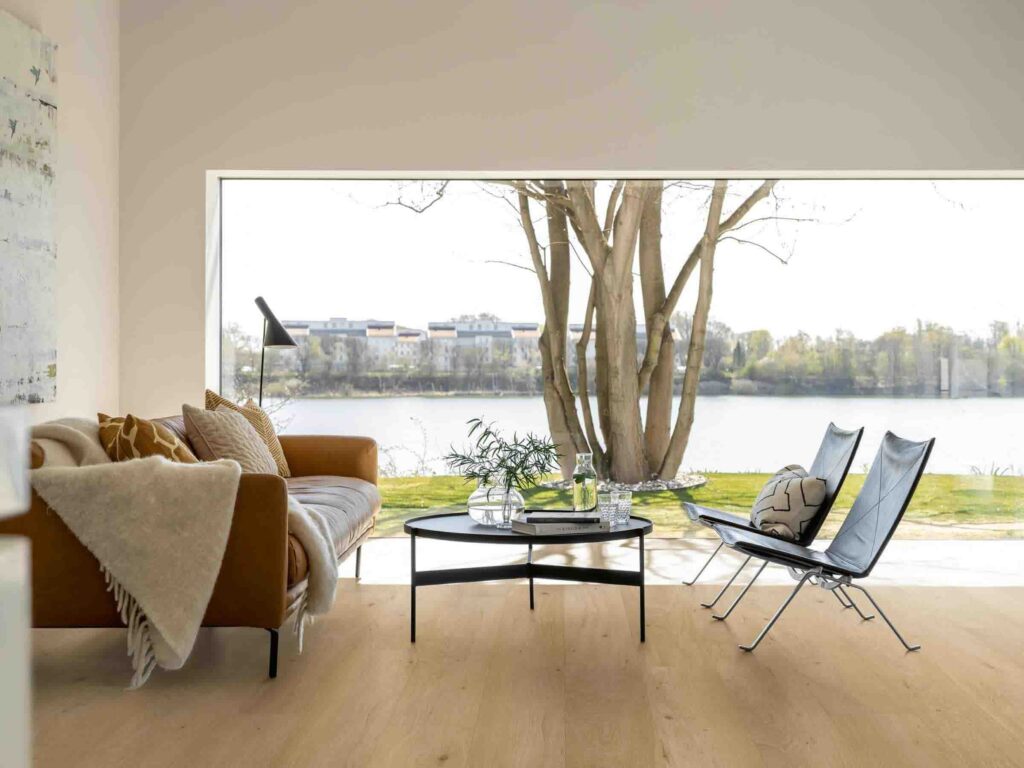 Modernes Wohnzimmer mit hellem Eichen-SPC-Boden am Seeufer