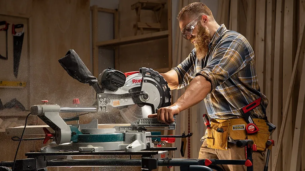 Carpenter using circular miter saw to cut wood precisely.
